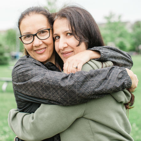 Daniela et Patricia se donnent une accolade dans un parc.