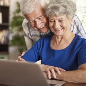 Older couple looking at laptop smiling